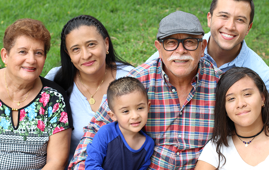 Multi-generational family in the park, smiling for the camera